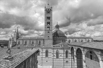 Dark clouds over the cathedral of Siena with its black and white striped marble facade