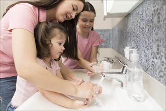 Mother learning girl wash hands