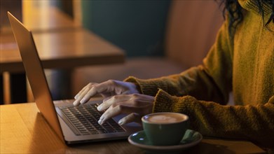 Sideways woman working her laptop coffee shop