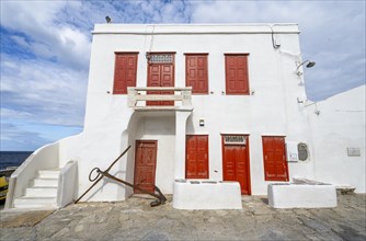 White Cycladic house with red shutters and doors
