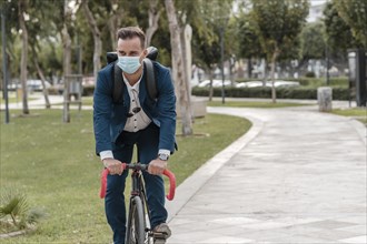 Man riding bike while wearing medical mask