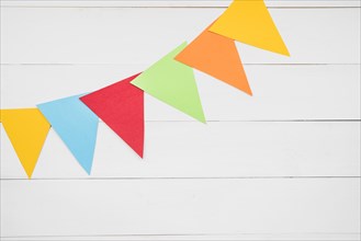 Colorful triangular bunting white wooden plank