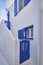 Traditional Greek house on Cyclades or Aegean islands. Whitewashed walls and dark blue doors
