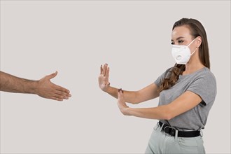 Woman with face mask refusing hand shake