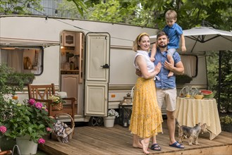 Long shot family posing their caravan