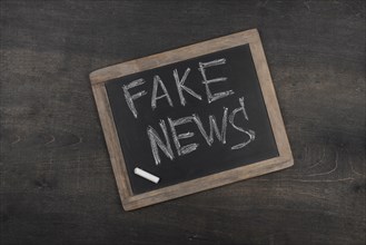 Fake news concept with blackboard top view
