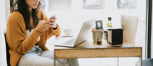 Crop woman using smartphone cafe