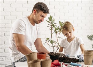 Father son planting plants home