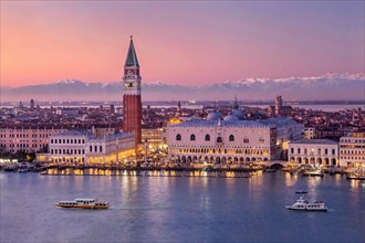 Waterfront with Campanile and Doge's Palace in front of the Alpine chain at dusk