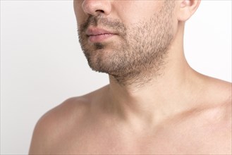 Close up shirtless stubble man against white background
