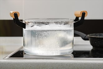 Preparation of poached egg in boiling water in glass pot