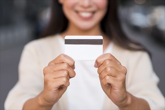 Smiley defocused woman holding credit card