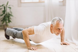 Senior man doing pushup exercise hardwood floor