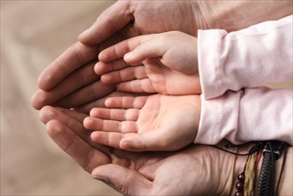 Top view little girl putting her hands father s hands