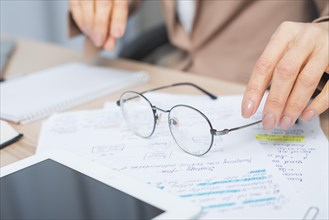 Close up woman s hand holding eyeglasses document