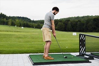 Professional golf player practising golf field