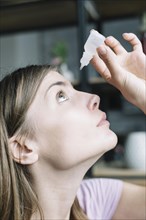 Close up woman putting eye drops