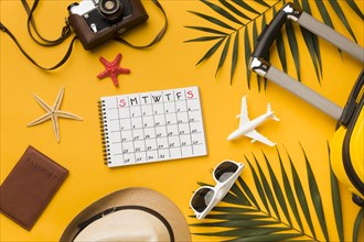 Flat lay travel essentials with calendar sunglasses