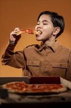 Medium shot kid eating pizza
