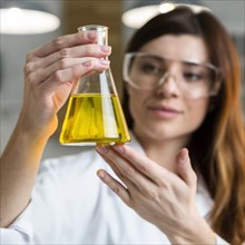 Defocused female scientist holding test tube