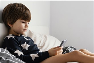 Kid bed holding smartphone
