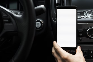 Close up hand holding smart phone showing white blank screen car