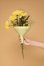 Close up woman hand with plastic funnel with flowers