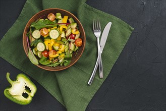 Halved bell pepper mixed vegetable salad green napkin black concrete backdrop