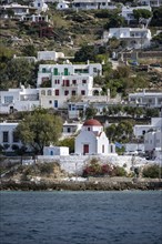 Small Greek Orthodox white church with red roof