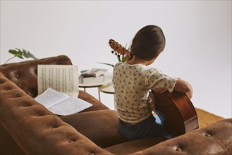 Little girl learning how play guitar home