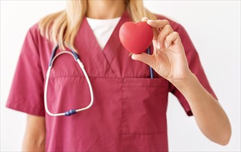 Front view female doctor holding heart shape