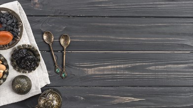 Turkish metallic spoons with dried dates raisin wooden desk
