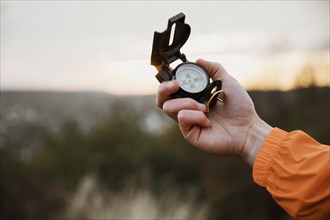 Man holding up compass while road trip