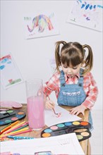 Cute girl painting with aquarelle paper