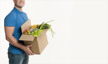 Side view delivery man posing with grocery box