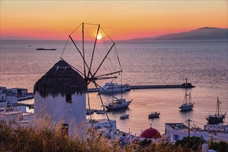 Famous traditional Greek windmill overlook port and harbor of Mykonos