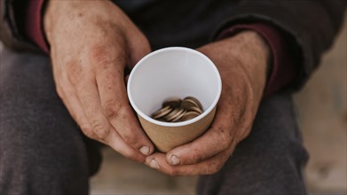 Front view homeless man holding cup with coins