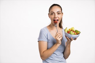 Woman eating tomato with fork