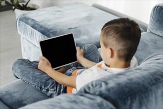 Shoulder view boy using digital tablet