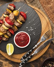 Top view delicious kebab slate with ketchup cutlery