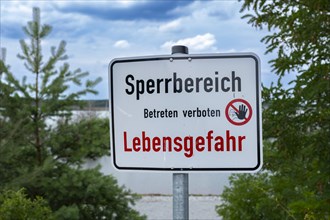 Sign with the inscription Sperrbereich Betreten verboten Lebensgefahr on the shore of Lake Senftenberg