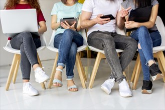 Low section view people sitting chair using wireless devices