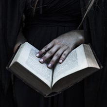 Hands woman black clothes holding opened book