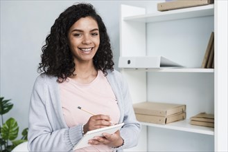 Happy young woman with scratchpad office