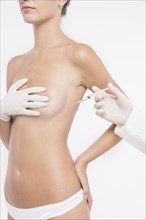 Plastic surgeon injecting woman breast