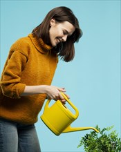 Medium shot woman with watering can