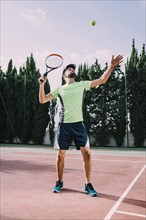 Tennis player green t shirt serving