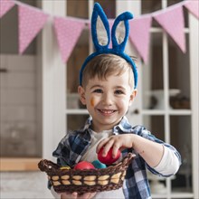 Portrait adorable little boy holding basket with eggs