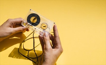 Person holding broken cassette tape with copy space
