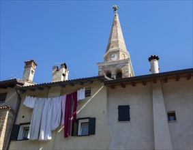 Laundry hanging to dry on a house facade with the Basilica of Sant Eufemia